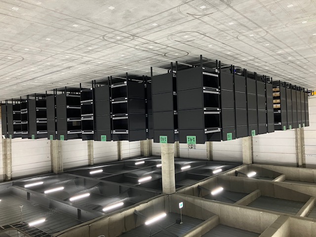 棚に歩いていかなくても、黒い棚が自動で到着。入荷も出荷も歩かずに楽ちん作業。